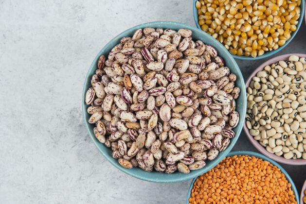 食物大理石表面有一堆各种生豆子 玉米和红扁豆品种玉米豆类