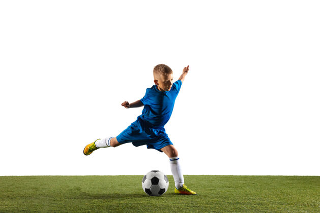 比赛穿着运动服的足球或足球运动员的小男孩在白色工作室背景上用球假装或踢进球适合在比赛中扮演男孩的动作 动作 动作比赛制服活动