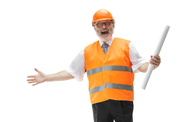 人员一个穿着建筑背心 戴着橙色头盔的快乐的建设者在工作室微笑安全专家 工程师 工业 建筑 经理 职业 商人 工作理念专家工人技术