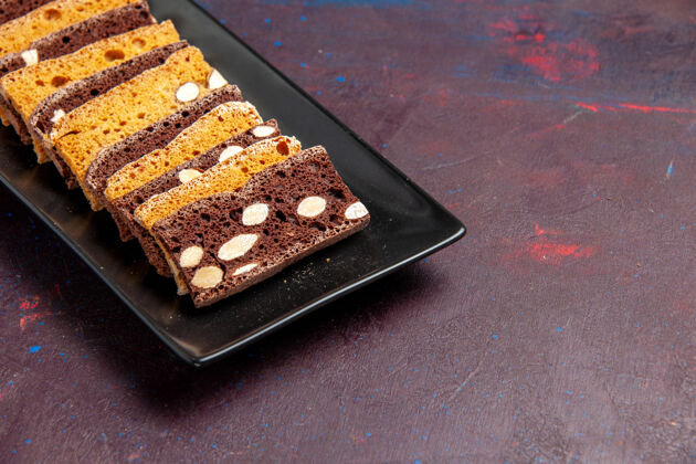 饼干前视图美味的切片蛋糕与坚果蛋糕锅内黑暗的空间巧克力食物平底锅