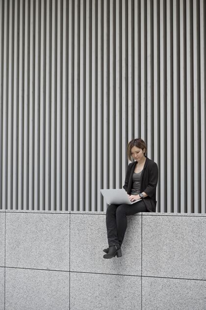 城市在笔记本电脑上工作的女人现代成人女性