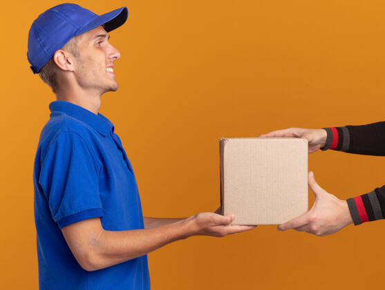 Cardbox微笑着的年轻金发送货员站在一旁 把名片盒给了别人橙色侧身年轻
