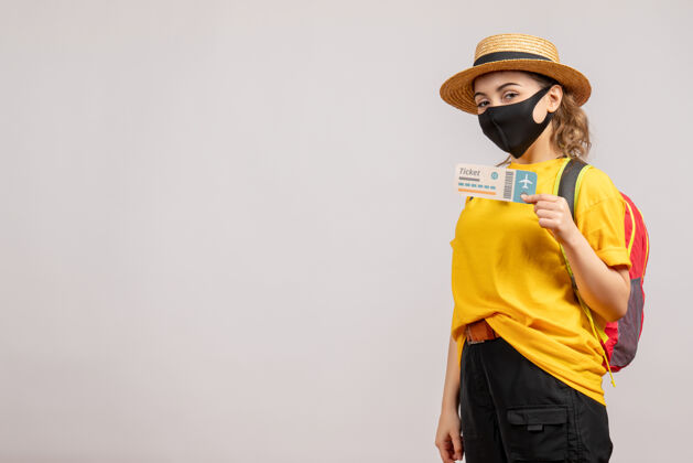 女人正面图戴着黑色面具的年轻女子拿着旅行票人面罩人