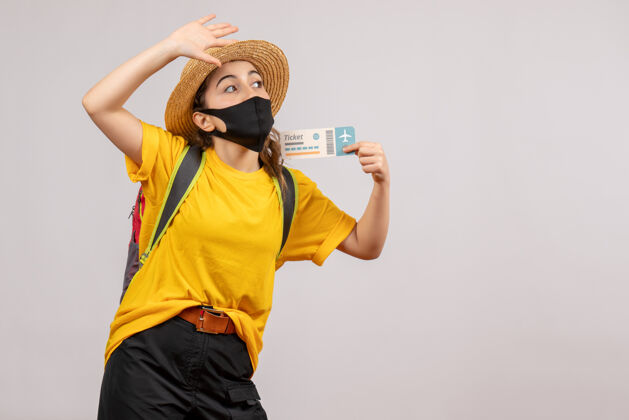 人正面图背着背包的年轻旅客举着机票招呼着某人流行病保护套新常态
