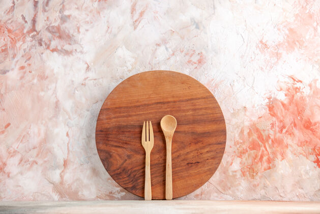 勺子站在彩色墙上的圆形木制砧板和勺子的俯视图圆形视图餐具