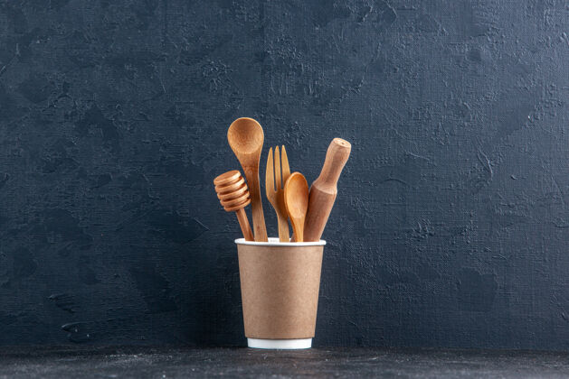 木制勺子黑色墙上的塑料咖啡壶里的木制厨房勺子俯视图视图壶物体