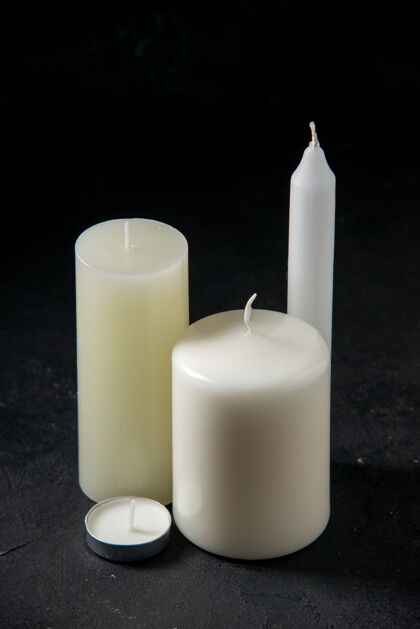 白蜡烛黑蜡烛上的白蜡烛的正视图葬礼蜡烛火焰
