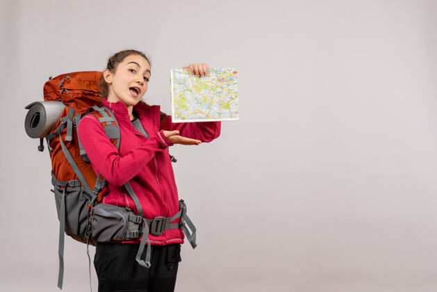 背包正面图年轻的旅行者用大背包指着地图女人人持有