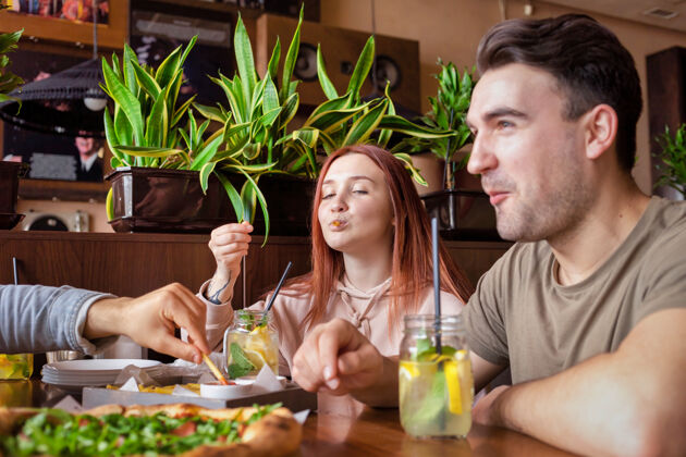 休息一群朋友在酒吧休息吃 喝 桌上的食物友谊餐厅快乐讨论