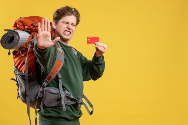 旅游正面图年轻男子手持红色银行卡准备远足自然付款情感