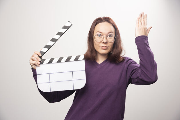 模型一个年轻的女人在一张白色的照片上摆着一个电影院的带子高质量的照片姿势镜头年轻人