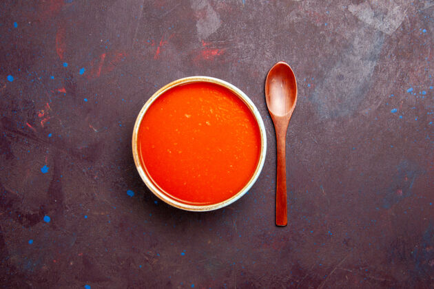 油漆俯瞰美味的西红柿汤 由新鲜西红柿在深色背景上烹制而成 酱汁一餐西红柿汤汤匙汤碗碗