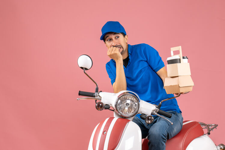 背景顶视图的快递员戴着帽子坐在滑板车上显示订单感到害怕粉彩桃背景男人摩托车滑板车