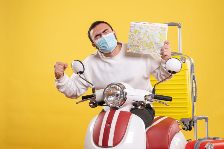 人旅行概念的俯视图 戴着医用面罩的骄傲快乐的家伙站在摩托车旁边 黄色手提箱放在摩托车上 手里拿着地图摩托车人卡通
