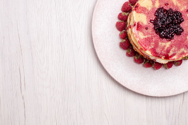 农产品俯瞰美味的薄煎饼与草莓和果冻的白色办公桌馅饼饼干甜浆果蛋糕可食用水果浆果甜点