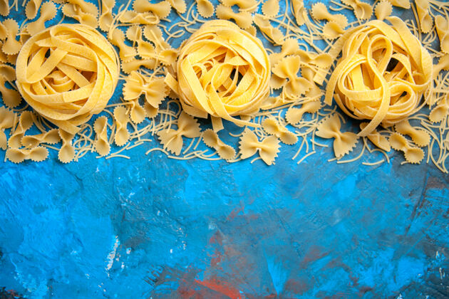 头顶晚餐准备的俯视图 蓝色背景上的意大利面排成一排背景准备晚餐
