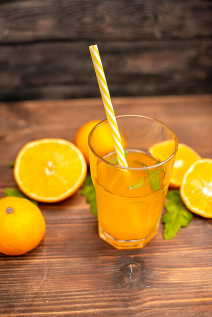 柠檬上图：木桌上盛着新鲜橙汁的玻璃杯里放着薄荷和切好的橙子食品玻璃薄荷