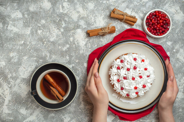 毛巾手拿美味奶油蛋糕装饰的红色毛巾上的水果俯视图杯背景奶油蛋糕