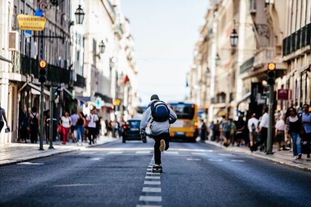 技巧溜冰者在拥挤的里斯本市中心的路中间游弋骑行活动城市