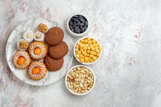 视图俯瞰美味的饼干与糖果和坚果的白色背景蛋糕饼干饼干甜甜的糖茶美味的饼干食物蛋糕