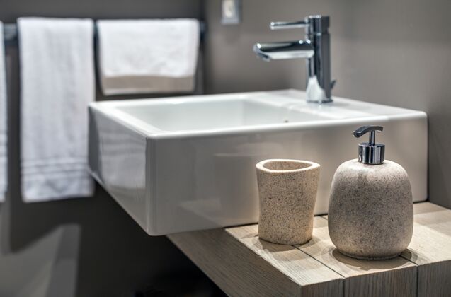 空浴室里瓶子旁边的现代水槽的浅浅照片家用明亮设计
