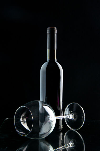 香槟正面是一瓶葡萄酒 背景是黑色的空杯子酒瓶空的液体