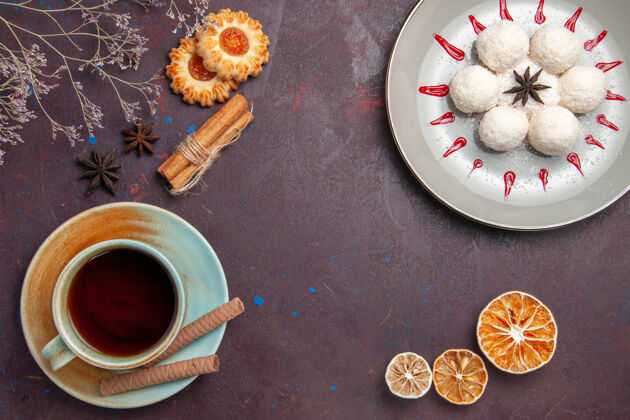 食物俯瞰美味的椰子糖小而圆的形成与茶的深色背景椰子糖茶甜饼饼干圆少量热的