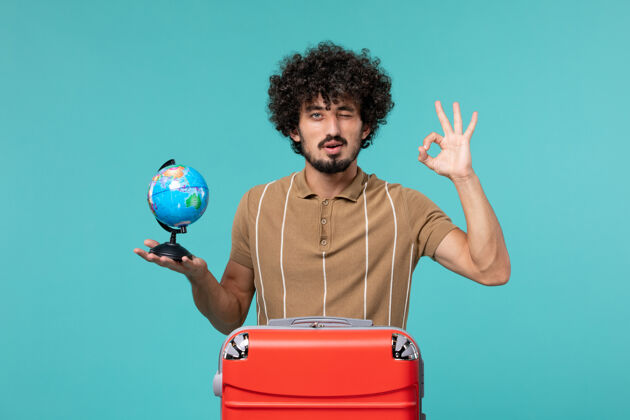 视图度假的人手里拿着一个蓝色的红色袋子的小地球仪旅行举行旅行