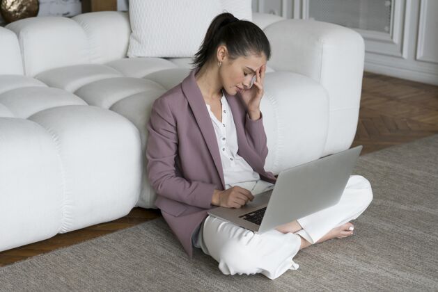 网络坐在地板上膝上放着笔记本电脑的女人科技笔记本电脑在线
