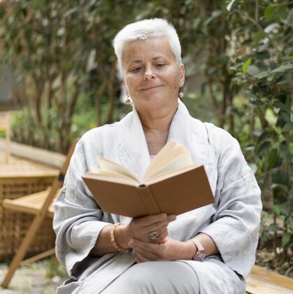 城市中等身材的女人在户外看书老年人老年人生活方式