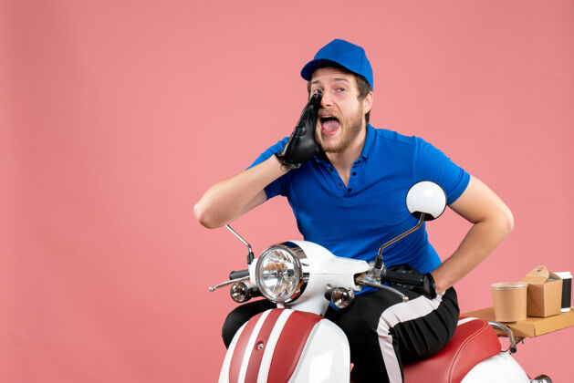 自行车正面图身着蓝色制服的男快递员在粉红色的食品上打电话自行车送货工作颜色工作服务快餐车辆男信使电话