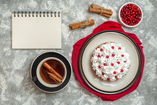 肉桂上图：红色毛巾上点缀着水果的美味奶油蛋糕和一杯红茶醋栗酸橙水果