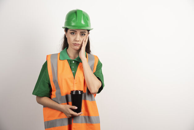制服心烦意乱的女施工员拿着黑杯子高质量的照片建筑师热茶