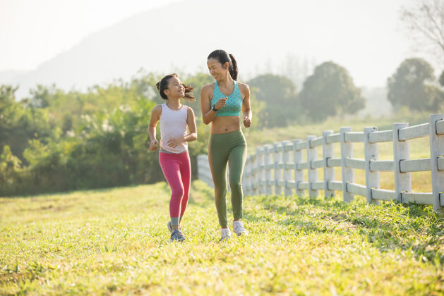 健康跑鞋女跑步者在森林公园为秋季跑步系鞋带跑步者试着穿跑鞋准备跑步慢跑女孩锻炼动机健康和健身温暖的阳光照耀活跃慢跑家庭