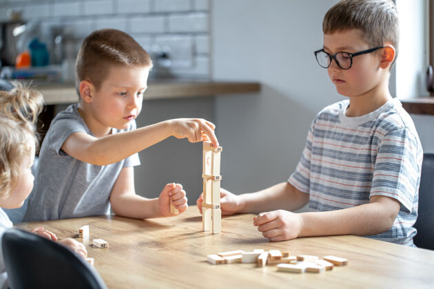 建筑小孩子在家里的厨房里用木块玩棋盘游戏棋盘娱乐棋盘游戏