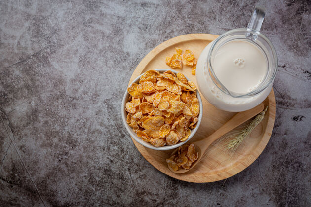 白色碗里的麦片和深色背景上的牛奶麦片谷物桌子