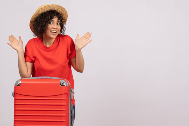微笑正面图年轻女性带着红包准备在白色背景上旅行休息度假阳光色旅游航班飞机航行旅行年轻女性美丽
