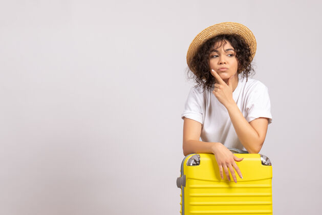 包正面图年轻女性带着黄色的包准备乘坐白色背景色的航班旅行度假飞机休息旅游者美丽帽子人