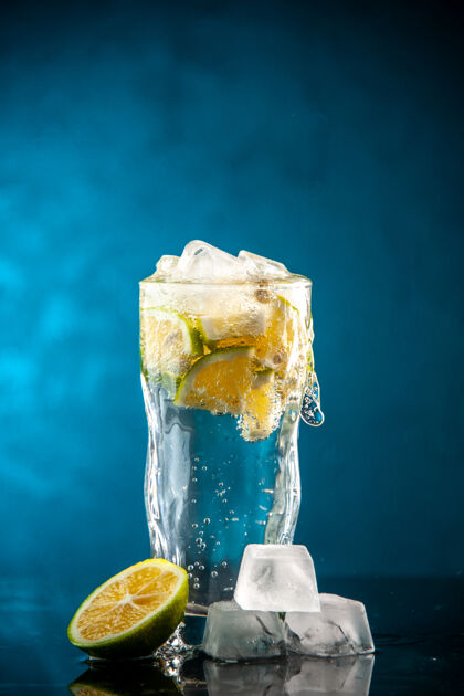 水晶一杯苏打水配柠檬片和冰块 配上一杯蓝照片香槟鸡尾酒柠檬水前面立方体鸡尾酒