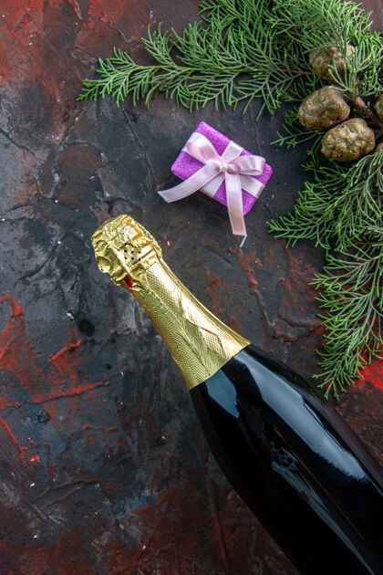 衣服顶视图一瓶香槟与礼物上深色饮料酒精照片新年派对草礼物聚会