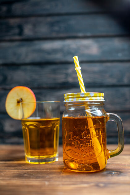 前面正面图新鲜苹果汁罐内和玻璃上的棕色木制书桌照片鸡尾酒水果饮料的颜色桌子玻璃酒精