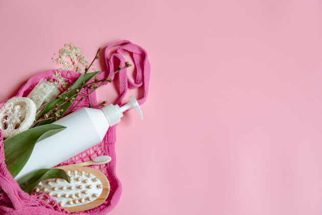 粉色平铺温泉组成与个人卫生用品和浴室配件在一个字符串袋瓶子套装绳袋