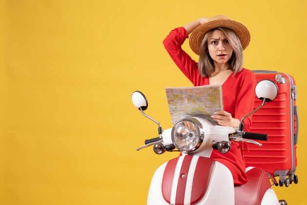 手提箱骑着轻便摩托车 带着红色手提箱的漂亮年轻女子拿着地图地图设备信息