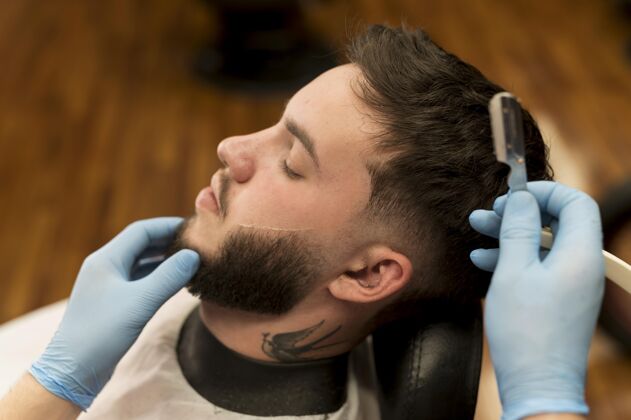 乳胶手套理发师剃须和轮廓男客户的胡须雇员理发师剃须刀片
