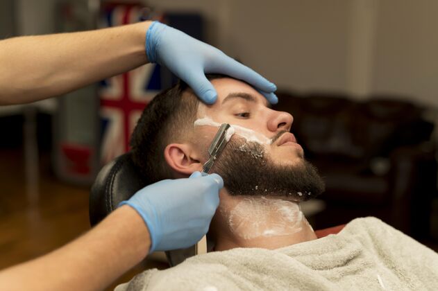 职业理发师剃须和轮廓男客户的胡须乳胶手套职业专业