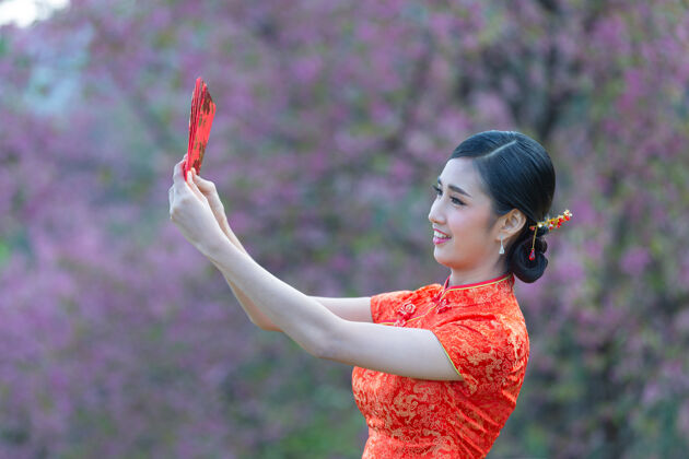 空白美丽的亚洲女人在中国的新年里展示一些东西和拿红包空白女性信封
