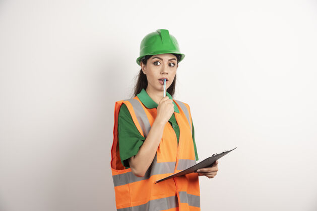 工作拿着商务纸和铅笔的女工程师高质量的照片工作女士头盔