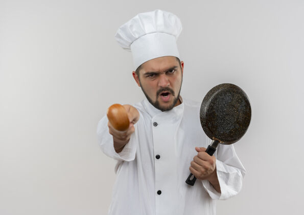 烹饪愤怒的年轻男厨师身着厨师制服 手拿煎锅 伸出勺子 隔离在白色墙壁上 留有复印空间制服年轻勺子