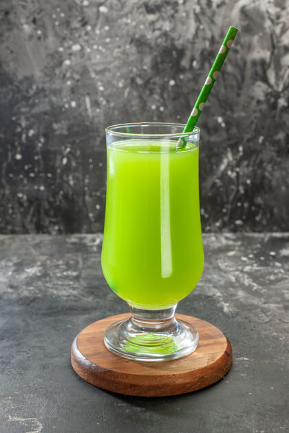 前面正面图绿色的苹果汁在玻璃里面用吸管放在浅色照片上喝鸡尾酒吧水果稻草鸡尾酒玻璃