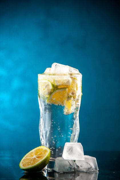 立方体一杯苏打水加柠檬片和冰块放在蓝色照片上香槟水鸡尾酒喝柠檬水柠檬冷水